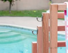 a towel hanging on a wooden rail next to a pool