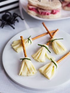 small pieces of food are arranged on a white plate with toothpicks sticking out of them