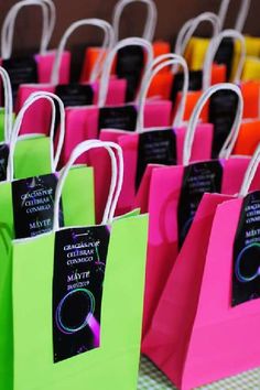 colorful bags with black tags on them are lined up in the shape of small rectangles