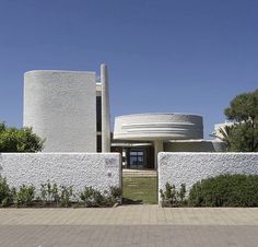 a white building with a circular entrance in front of it