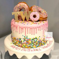 a birthday cake with donuts and sprinkles on top that says twp