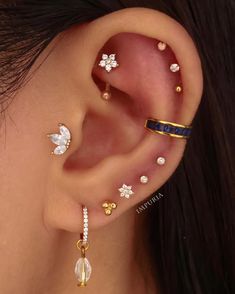 a woman with three different ear piercings on her left side and one behind the ear