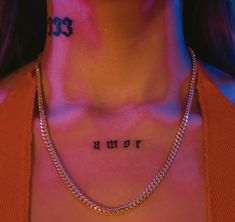 a woman with tattoos on her chest and name written on the chest, in black ink