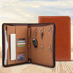 an open brown leather wallet with keys and keychains on the inside is shown