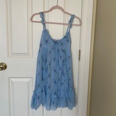 Never Worn, Beautiful Sun Dress. Doubled Lined. Adjustable Straps And Tie In Front Light Blue Sleeveless Floral Mini Dress, Light Blue Sleeveless Floral Dress For Summer, Blue Floral V-neck Dress For Daywear, Blue Sleeveless Flowy Floral Dress, Blue Flowy Sleeveless Floral Dress, Blue Flowy Floral Dress With Ruffles, Casual Sleeveless Blue Floral Dress, Flowy Blue Floral Dress With Ruffles, Flowy Blue Floral Mini Dress