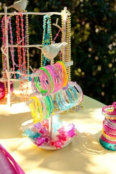 a table topped with lots of colorful bracelets