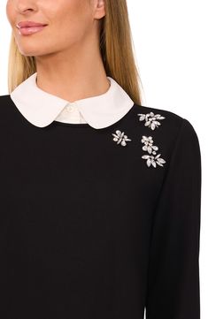 Pull together a preppy look that saves on closet space in this jewel-embellished sweater finished with a club collar and ruffled cuffs. 21" length (size medium) Club collar Long sleeves 67% rayon, 26% nylon, 7% spandex Machine wash, tumble dry Imported Elegant Fall Tops With Embellished Collar, Chic Tops With Embellished Collar For Fall, Elegant Long Sleeve Embellished Tops, Party Tops With Embellished Collar, Black Long Sleeve Top With Embellished Collar, Black Long Sleeve Tops With Embellished Collar, Embellished Sweater, Embellished Sweaters, Ruffle Sweater