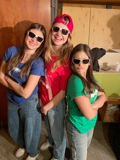 three girls in sunglasses posing for the camera