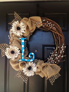 a wreath that has the letter j on it and some flowers in front of it