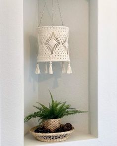 a potted plant sitting on top of a white shelf next to a light fixture