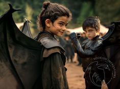 two young children dressed in costumes standing next to each other with bats on their shoulders