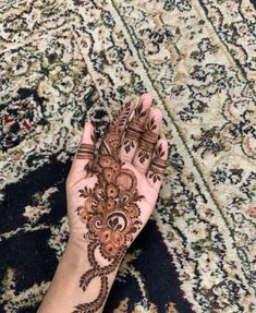 a woman's hand with henna tattoos on it