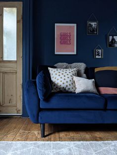 a blue couch sitting in front of a pink wall with the words dark blue lounge before and after