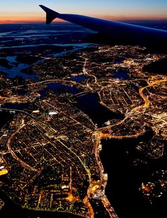 an airplane wing flying over a city at night