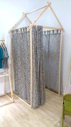 an image of a room with curtains and clothes on the rack in front of it