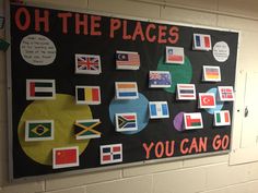 a bulletin board with flags on it in a school hallway that says oh the places you can go