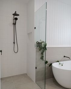 a white bath tub sitting next to a walk in shower