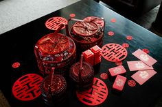 the table is covered with red paper cutouts and decorative objects on top of it