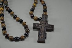 Orthodox Beads Necklace in religious style with the use of , wenge wood, agate, Tiger's Eye, hematite.  The Christian cross is made of pear wood on a milling machine and finished by hand. You will receive a strong religious amulet that combines the power of wood, stones and your faith. Size: 27 inches If you need a different size, please email me. All items from this shop are handmade and done with love. ♥ ♥ ♥ Wooden Cross Necklace, Wooden Man, Wenge Wood, Pear Wood, Christian Necklace, Necklace Men, Wooden Necklace, Wooden Cross, Milling Machine