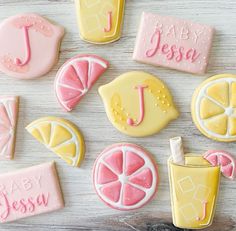 decorated cookies with lemons, grapefruit and icecream are arranged on a table