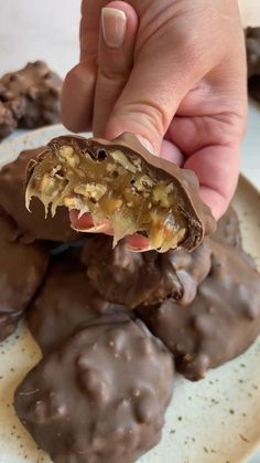 a person is holding up some chocolate covered cookies