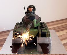 a cake made to look like a tank with a person on it and some sparklers in the air