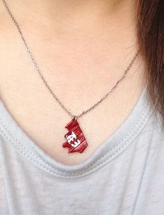 a close up of a person wearing a necklace with a red object on it's neck