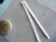 two white toothbrushes sitting next to each other on top of a gray table