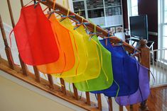 there are many colorful bags hanging from the banister