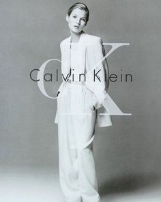 a woman standing in front of a gray background with the words calvin klein on it