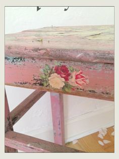 an old wooden bench with flowers painted on it