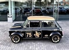 an old black and tan car parked in front of a building