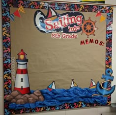 a bulletin board with an image of a lighthouse and sailboats in the ocean on it