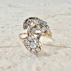 A beautiful vintage 14 karat yellow gold diamond cocktail ring. It centers a marquise diamond weighing approximately 0.30 carat. It is surrounded by 14 round diamonds weighing approximately 0.30 carat The diamonds are approximately G-H in color and VS1 in clarity. Stamped 14K. It weighs 4.6 grams. Size 5.25 US / K UK. > Resizing included. This ring can be resized to fit most fingers. Please contact us for details. Resized rings are final sale. Free resizing does not apply to discounted rings ove Marquise Multi-stone Diamond Ring, Marquise Cut Multi-stone Diamond Ring For Anniversary, Gold Marquise Cut Multi-stone Diamond Ring, Heirloom Multi-stone Marquise Cut Diamond Ring, Marquise Cut Multi-stone Yellow Gold Diamond Ring, Marquise Diamond Ring, Gold Promise Rings, Diamond Cocktail Ring, Diamond Promise Rings