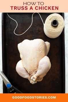 a raw chicken sitting on top of a pan next to a spool of thread