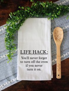 a tea towel that says life hack on it next to a wooden spoon