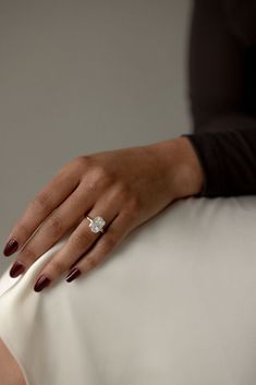 a woman's hand on the back of a chair with a ring on it