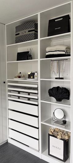 an organized closet with white shelves and drawers