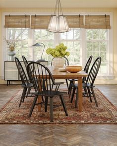 a dining room table with chairs and a rug