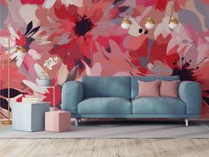 a blue couch sitting in front of a pink flower wallpapered living room area