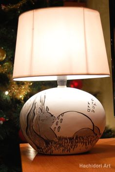 a lamp that is sitting on top of a wooden table next to a christmas tree