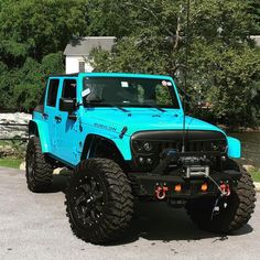 a bright blue jeep parked in front of a house