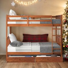 there is a bunk bed next to a christmas tree with lights on the top and bottom