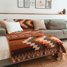 a living room filled with furniture and pictures hanging on the wall above it's couch