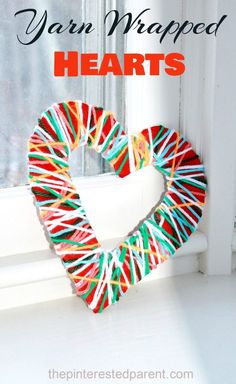 a heart shaped wreath sitting on top of a window sill with the words yarn wrapped hearts