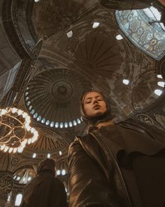 a woman standing in front of a chandelier