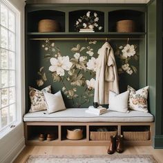 a bench with some pillows on it next to a coat rack filled with coats and shoes