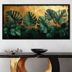 a table with a black bowl on top of it and a painting hanging above it