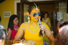 a woman with yellow paint on her face and some other people in the back ground