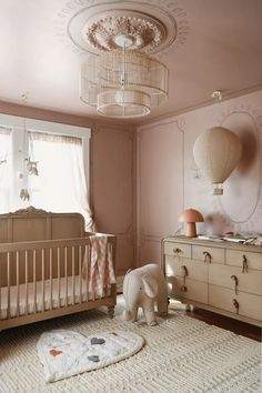 a baby's room with a crib, dresser and bed in it that has an elephant rug on the floor